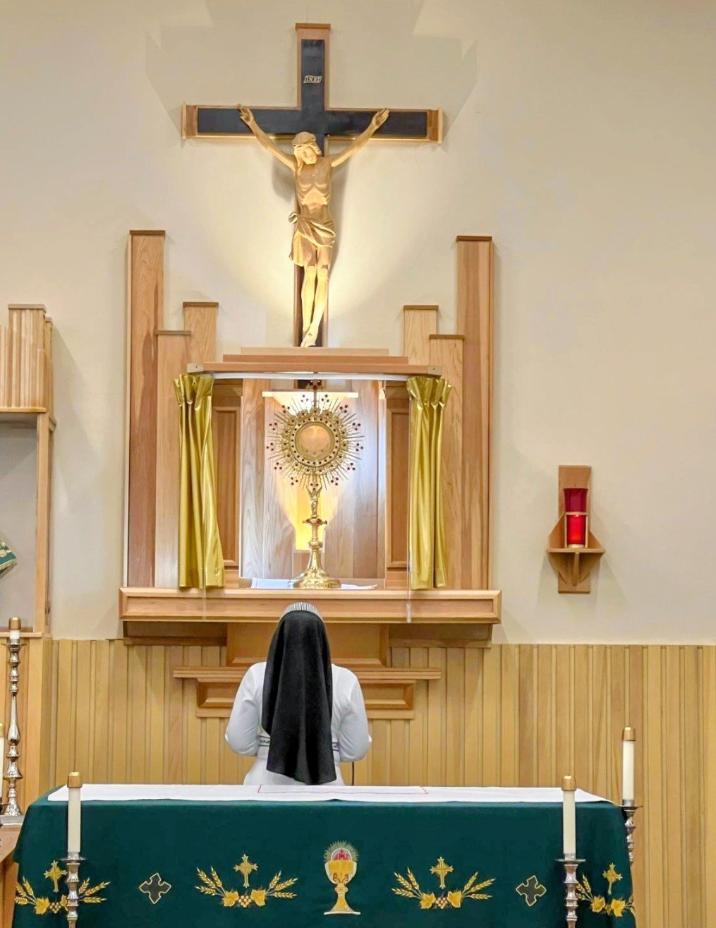 A member of the Anima Christi Missionaries of Consolation kneeling in Eucharistic adoration before the Blessed Sacrament