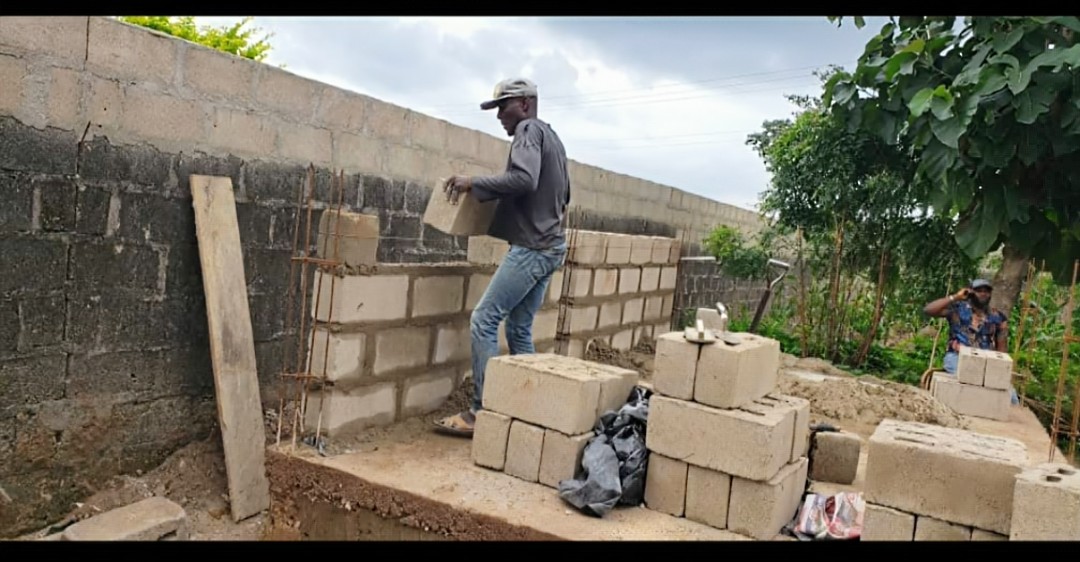 Workers laying blocks during construction of St. Clare Formation House